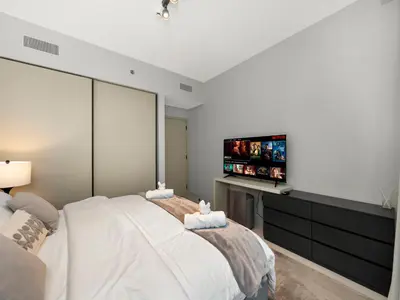 a bedroom with a large bed and a flat screen tv at Designer Large 1 BR with Private Beach Infinity pool in Dubai Harbour in Dubai
