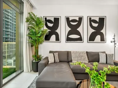 a living room with a couch and some plants at Designer Large 1 BR with Private Beach Infinity pool in Dubai Harbour in Dubai