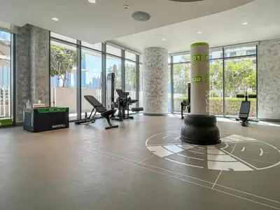 a large room with a gym with treadmills and chairs at Designer Large 1 BR with Private Beach Infinity pool in Dubai Harbour in Dubai