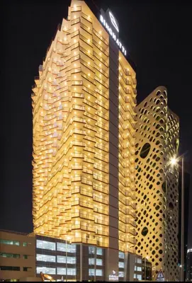 a tall building with lights on it at night at Business Bay Gem , Burj Khalifa View in Dubai