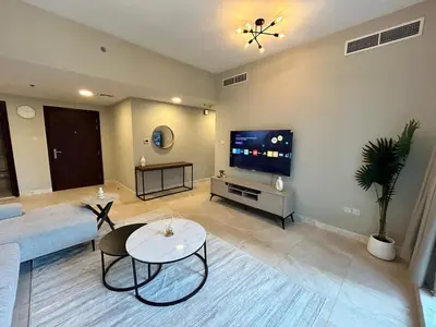 a living room with a couch and a tv at 1BR Apt in Business bay close to canal and Dubai mall! in Dubai