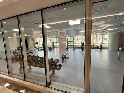 an empty gym with glass doors and a room with weights at 1BR Apt in Business bay close to canal and Dubai mall! in Dubai