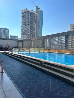 a large swimming pool in a city with tall buildings at 1BR Apt in Business bay close to canal and Dubai mall! in Dubai