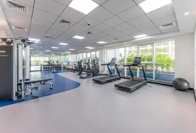 a gym with several treadmills and cardio machines at Charming 1BR in Orchid Residence, Al Barsha South by Deluxe Holiday Homes in Dubai