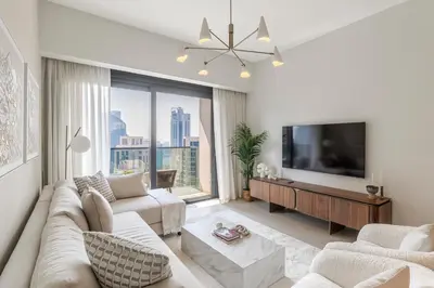 a living room with a couch and a tv at 1BR Act One Act Two T2 City View Downtown in Dubai