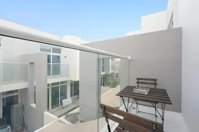 a balcony with a wooden table and a bench at Luxurious 3BDR Serenity Awaits in Damac Hills 2 in Dubai