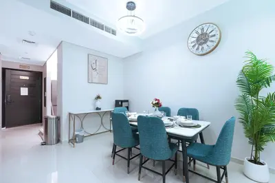 a dining room with a table and chairs and a clock at Luxurious 3BDR Serenity Awaits in Damac Hills 2 in Dubai