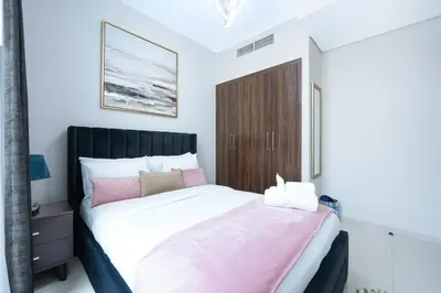 a bedroom with a large bed with a wooden cabinet at Luxurious 3BDR Serenity Awaits in Damac Hills 2 in Dubai