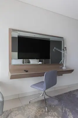 a desk with a monitor on a wall with a chair at Cozy 1BR with balcony great view, Damac Towers in Dubai