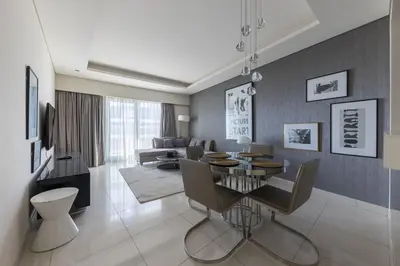a living room with a table and a dining room at Cozy 1BR with balcony great view, Damac Towers in Dubai