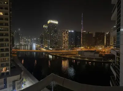 a view of a city at night with a body of water at Urban Cozy 1BR apartment with Canal view - Free parking in Dubai