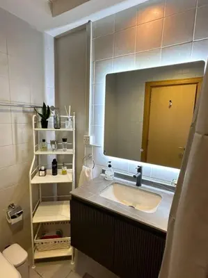 a bathroom with a sink and a large mirror at Urban Cozy 1BR apartment with Canal view - Free parking in Dubai