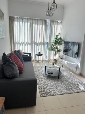 a living room with a black couch and a table at Urban Cozy 1BR apartment with Canal view - Free parking in Dubai