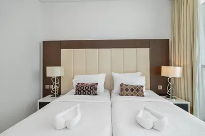 two beds in a hotel room with two lamps at Luxury 3BR Burj Khalifa View Infinity Pool Spa Gym in Dubai