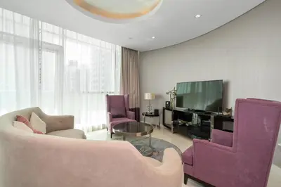 a living room with purple furniture and a tv at Luxury 3BR Burj Khalifa View Infinity Pool Spa Gym in Dubai
