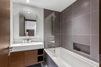 a bathroom with a sink and a tub and a mirror at Stunning 1BDR with Resort Style in Creek Harbour in Dubai