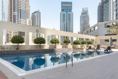 a swimming pool in a city with tall buildings at FIRST CLASS 1BR Charming Marina Escape in Dubai