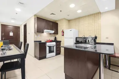 a kitchen with a counter top and a refrigerator at FIRST CLASS 1BR Charming Marina Escape in Dubai