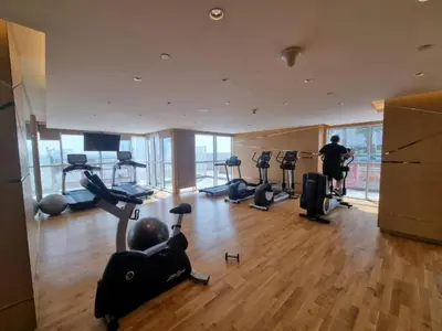 a gym with treadmills and exercise equipment in a building at Chic Studio in Damac Hills Carson B, Dubailand by Deluxe Holiday Homes in Dubai