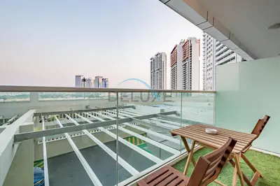 a balcony with a wooden table and chairs at Chic Studio in Damac Hills Carson B, Dubailand by Deluxe Holiday Homes in Dubai