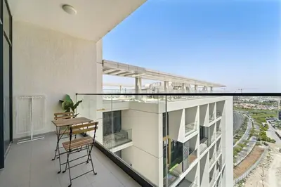 a balcony with a table and chairs on a building at Modern Studio Near To Park in Dubai