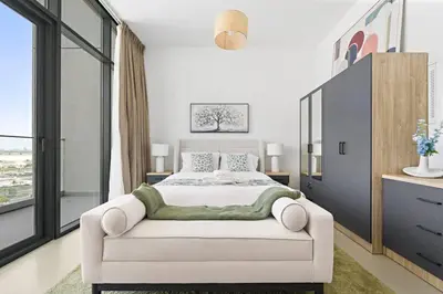 a bedroom with a white bed and a white couch at Modern Studio Near To Park in Dubai