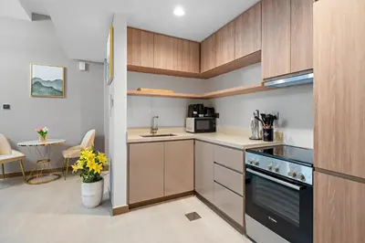 a kitchen with wooden cabinets and a stove top oven at ALiving Elegant 1BR I Near Burj Khalifa & Dubai Mall I Missoni Tower- 607 in Dubai