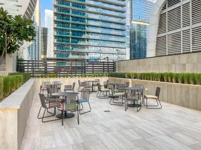 a row of tables and chairs on a patio with buildings at ALiving Elegant 1BR I Near Burj Khalifa & Dubai Mall I Missoni Tower- 607 in Dubai