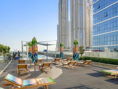 a group of chairs and umbrellas on a patio with buildings at ALiving Elegant 1BR I Near Burj Khalifa & Dubai Mall I Missoni Tower- 607 in Dubai