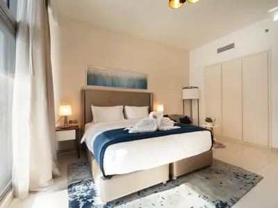 a bedroom with a large bed with towels on it at Cozy Studio Business Bay in Dubai