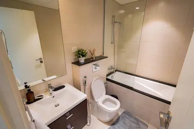 a bathroom with a toilet and a sink and a tub at Cozy Studio Business Bay in Dubai