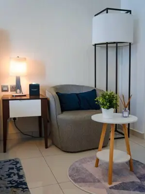 a living room with a couch and a table with a lamp at Cozy Studio Business Bay in Dubai