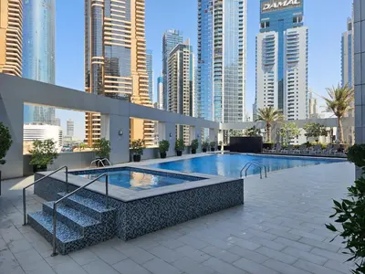 a pool in the middle of a city with tall buildings at Modern studio near the beach in Dubai
