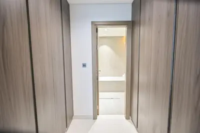 a hallway with a door to a bathroom with a shower at Spacious 1BR Burj Khalifa Views in District One Meydan in Dubai