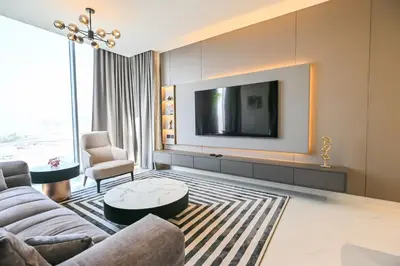 a living room with a couch and a tv at Stylish 1BR by the Lagoon in District One Meydan in Dubai
