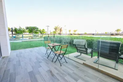 a patio with chairs and a table on a balcony at Direct Access to Crystal Lagoon 1br unit in District One Meydan in Dubai