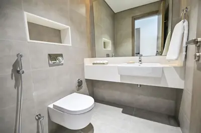 a bathroom with a white toilet and a sink at Amazing 1 Bedroom in District One Meydan in Dubai