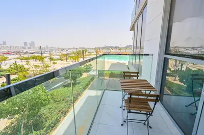 a balcony with chairs and a view of a pool at Amazing 1 Bedroom in District One Meydan in Dubai