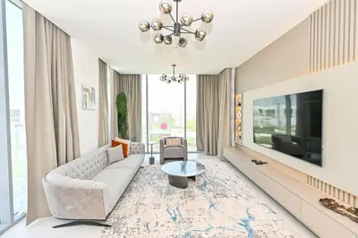 a living room with a couch and a tv at Amazing 1 Bedroom in District One Meydan in Dubai