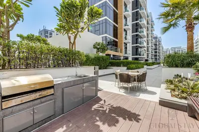 an outdoor entertaining area with a table and chairs and a building at GLOBALSTAY Azizi Riviera 45 in Dubai