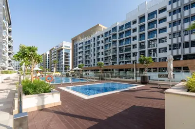 a swimming pool in front of a large building at GLOBALSTAY Azizi Riviera 45 in Dubai