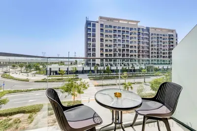 a balcony with a table and chairs and a building at GLOBALSTAY Azizi Riviera 45 in Dubai