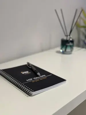 a notebook on a table with a pen on it at Jumeirah Heights in Dubai