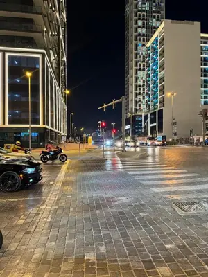 a city street at night with cars and buildings at Jumeirah Heights in Dubai