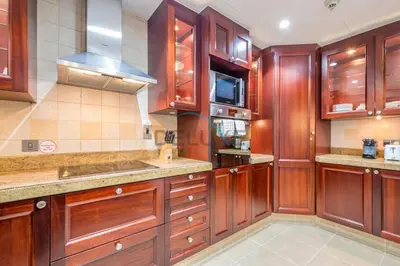 a large kitchen with wooden cabinets and counters at Appealing 1BR Apartment at Miska 2 Old Town, Downtown Dubai by Deluxe Holiday Homes in Dubai