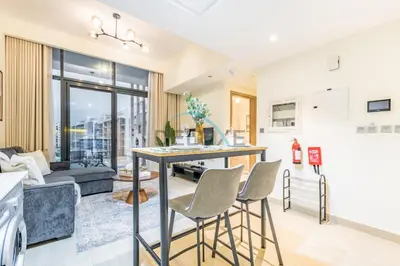 a kitchen and living room with a table and chairs at Relaxing 1BR Apartment with Built-in Wardrobe & Community View in Azizi Riviera 4, Al Merkadh by Deluxe Holiday Homes in Dubai