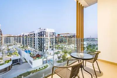 a balcony with a table and chairs and a view of a city at Relaxing 1BR Apartment with Built-in Wardrobe & Community View in Azizi Riviera 4, Al Merkadh by Deluxe Holiday Homes in Dubai