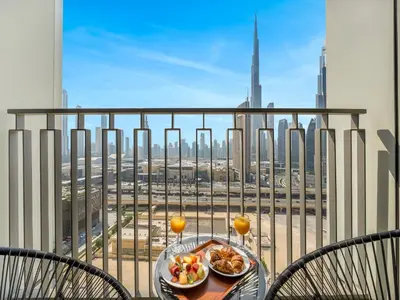 a table with a plate of food on a balcony at Amazing Stay Experience - Best Burj Khalifa View in Dubai