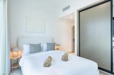 a bedroom with a large white bed with shoes on it at Stylish Home with Direct Pool Access by the Canal in Dubai
