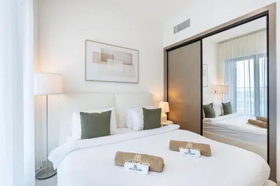 two beds in a hotel room with a mirror at Stylish Home with Direct Pool Access by the Canal in Dubai
